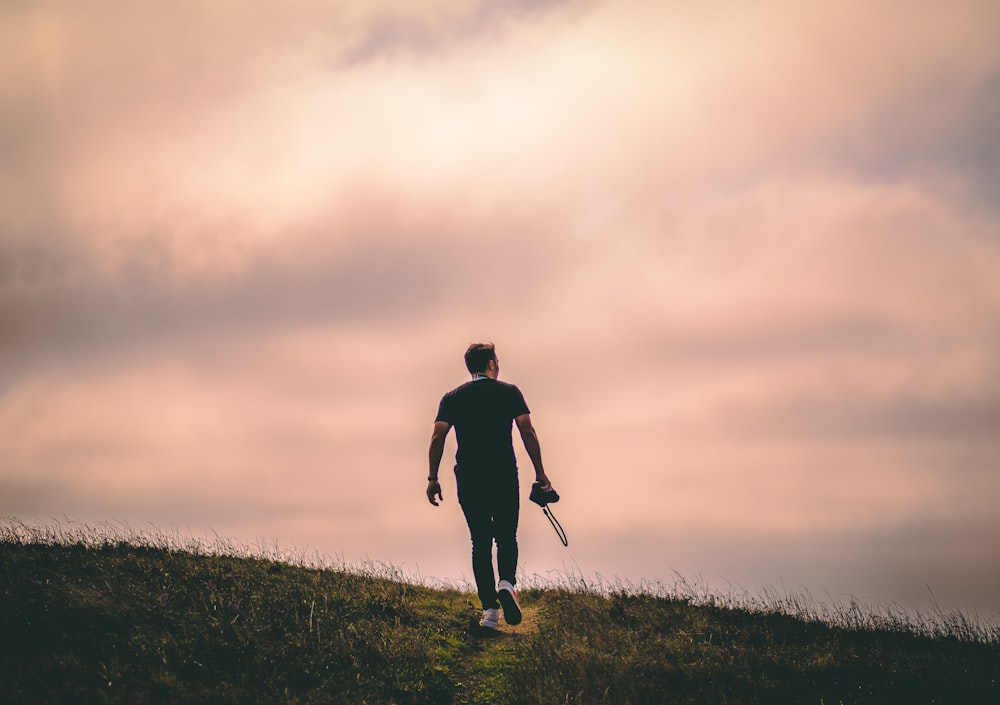 man walking on grass field