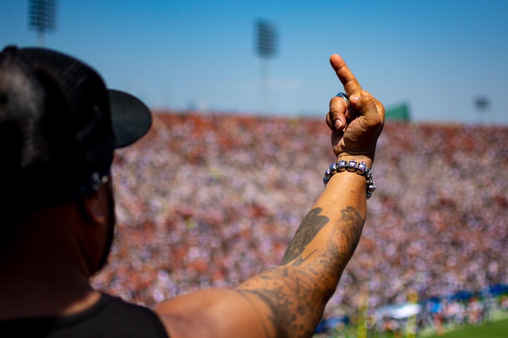 man in black tank top raising hand