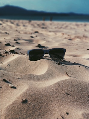 Close-up of stylish sunglasses on a beach towel.