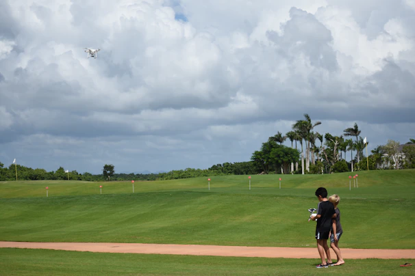 A local family watching a drone fly overhead, their faces lit with curiosity and wonder.