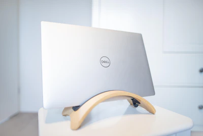 A Dell Latitude laptop angled to show its lightweight design and vibrant screen against a minimalist background