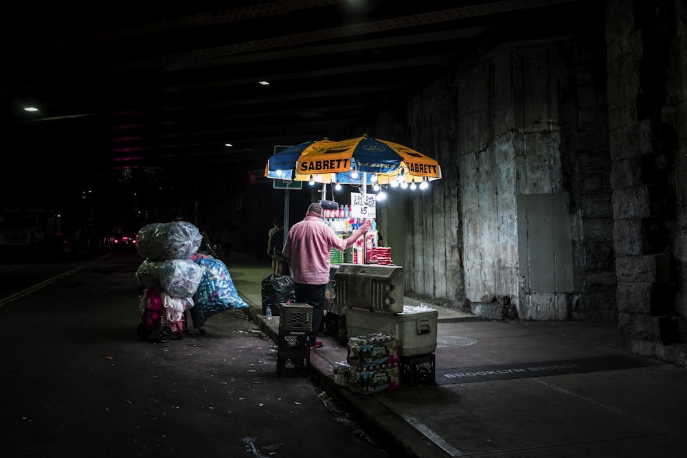 man under orange and blue canopy umbrella