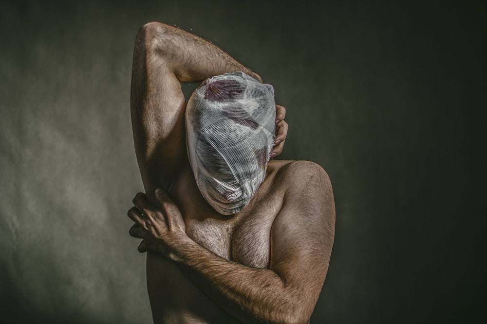 topless man covered face with white bandage