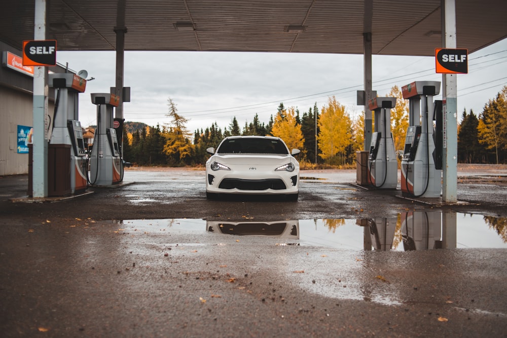 Weißes Fahrzeug an Tankstelle geparkt