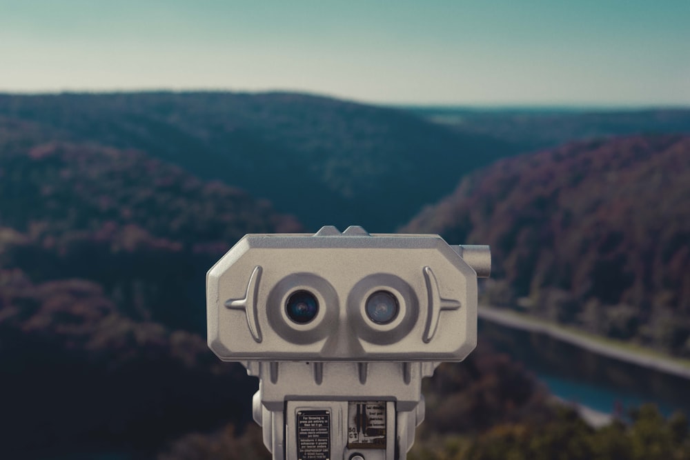 a close up of a camera with mountains in the background