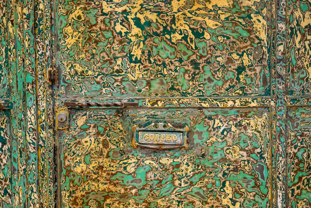 a close up of a green and gold door