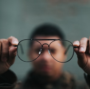 man holding eyeglasses