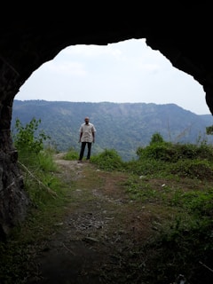 A stunning view of a cave entrance surrounded by lush greenery.