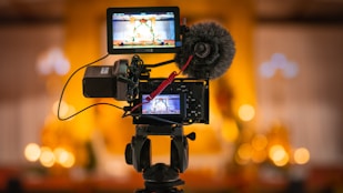 black video camera on black tripod