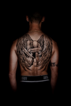 person with kneeling angel back tattoo