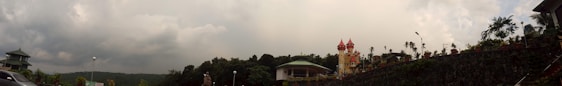 A panoramic view of the Kingdom Carinal's historic castle surrounded by lush forests under a bright sky.