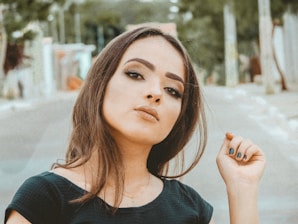 A joyful woman with styled hair and polished makeup looking confident outdoors.