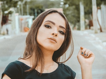 A joyful woman with styled hair and polished makeup looking confident outdoors.