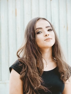 A young woman in a soft nude co-ord set standing confidently against a minimalist white wall.