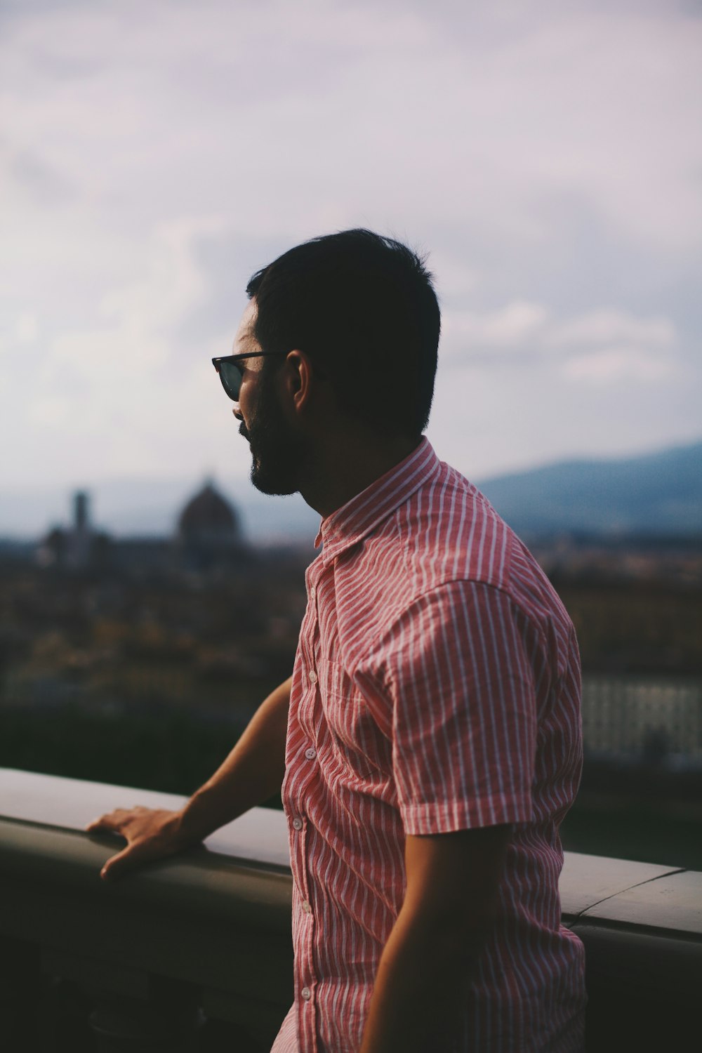 uomo in camicia a quadri rossa e bianca in piedi all'aperto