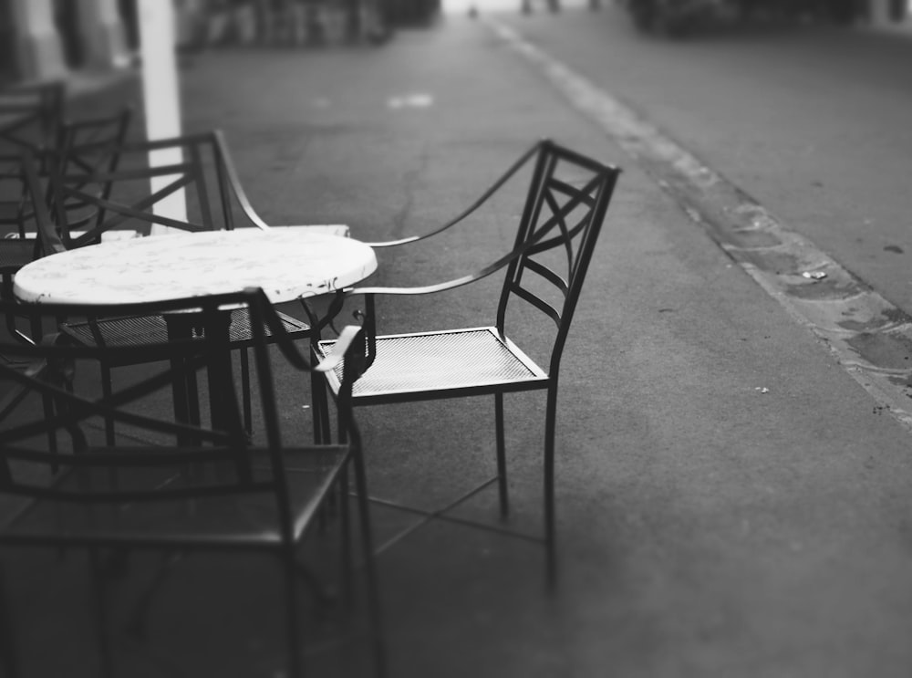 tavolo rotondo con quattro sedie appoggiate su piano di cemento