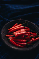 Behind-the-scenes shot of a team member shooting food photography with natural props and deep ripe crimson accents.