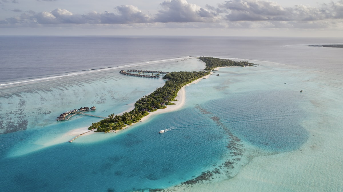 Outer Islands Seychelles — aerial view of a remote coral atoll surrounded by the deep blue Indian Ocean, far from the granitic inner islands
