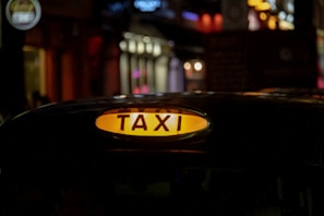 Evening shot of taxi under soft street lighting, highlighting clear signage