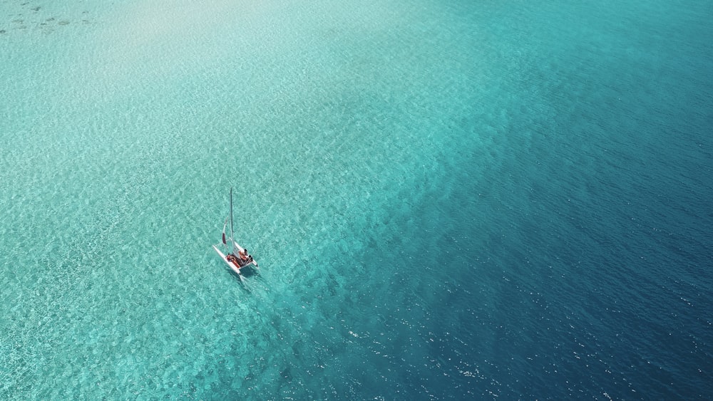 A catamaran sails across a shallow reef in the Maldives