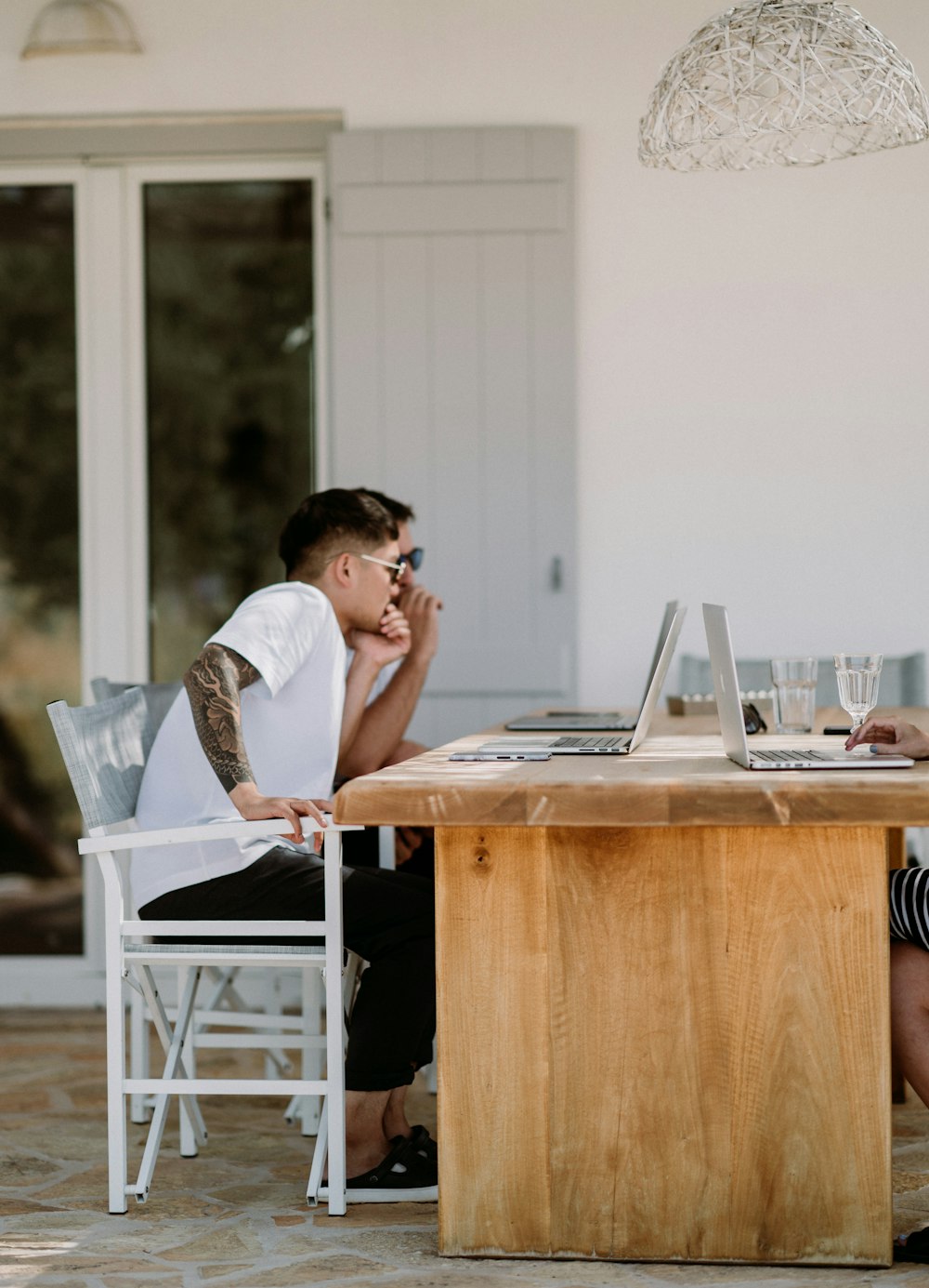 man sitting on armchair facing MacBook