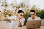two men using MacBooks