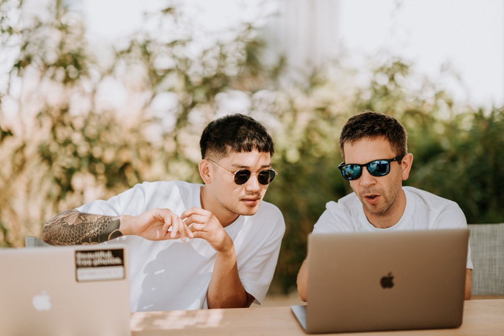 two men using MacBooks