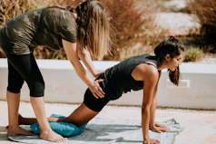 woman in black tank top and black shorts kneeling on mat