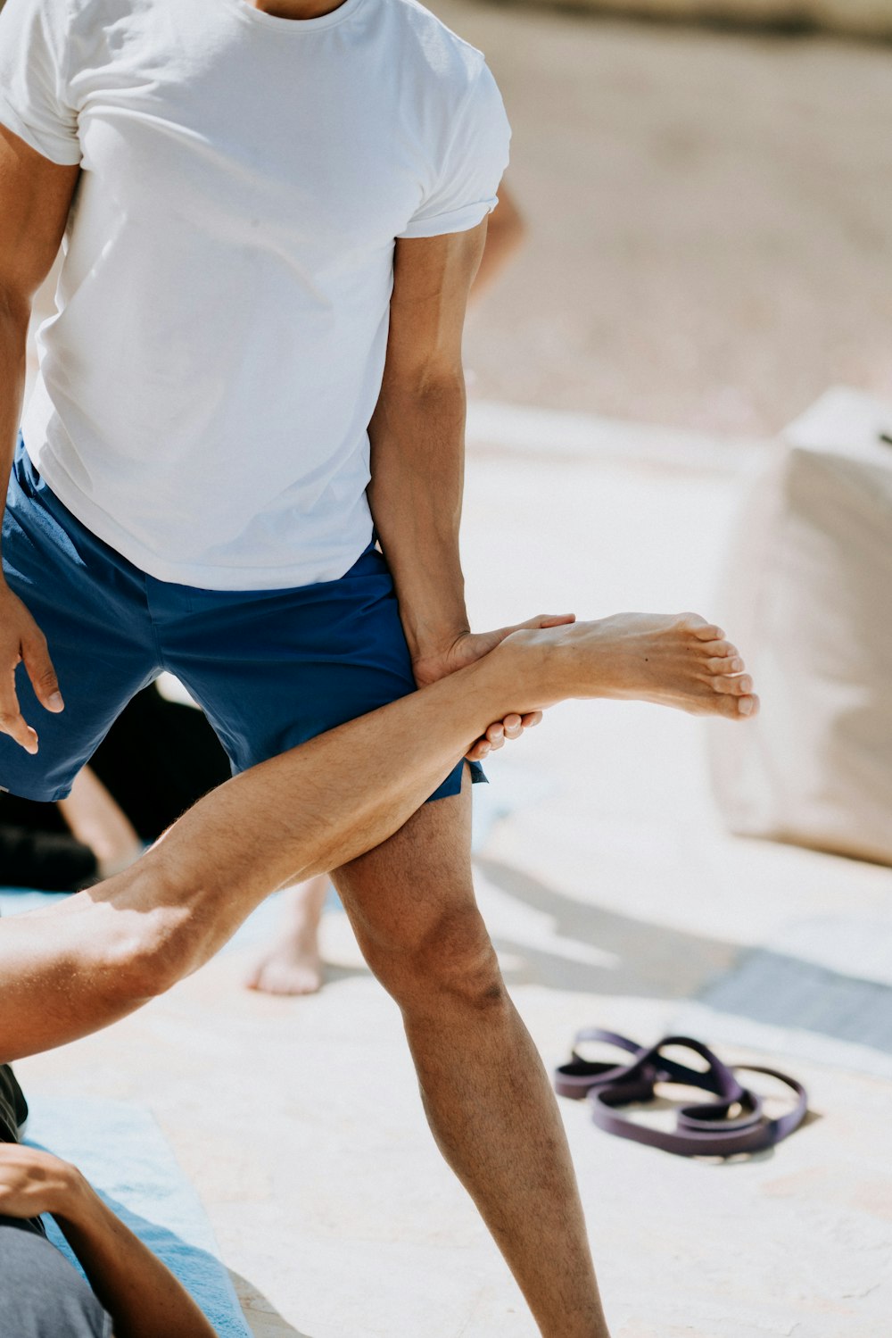 person wearing white crew-neck T-shirt and blue shorts