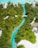 Aerial view of a vibrant tropical landscape featuring a winding turquoise stream bordered by lush green palm trees and vegetation. Sandy white pathways and a few buildings with thatched roofs are nestled within the greenery, and a small bridge crosses the stream.