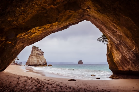 sea waves on shore through arch cave in Cathedral Cove New Zealand