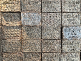 Several compressed blocks with intricate patterns and Chinese characters arranged in a grid formation. Each block appears textured and similar in size, reflecting aged and earthy tones.