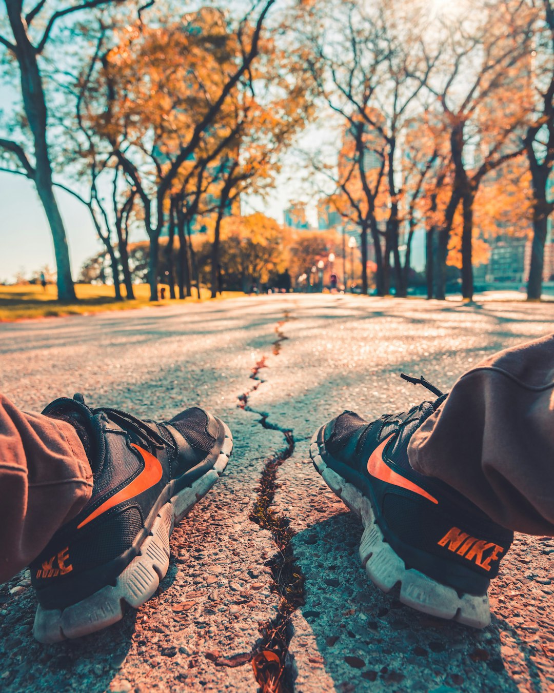 person wearing Nike running shoes sitting on road outdoor