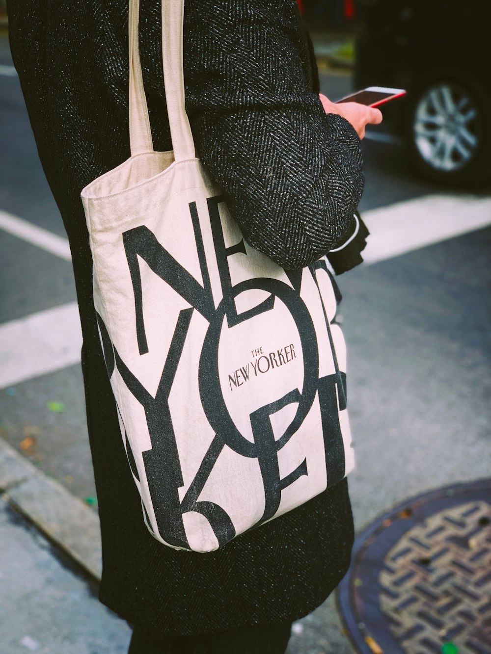 person carrying white and black tote bag