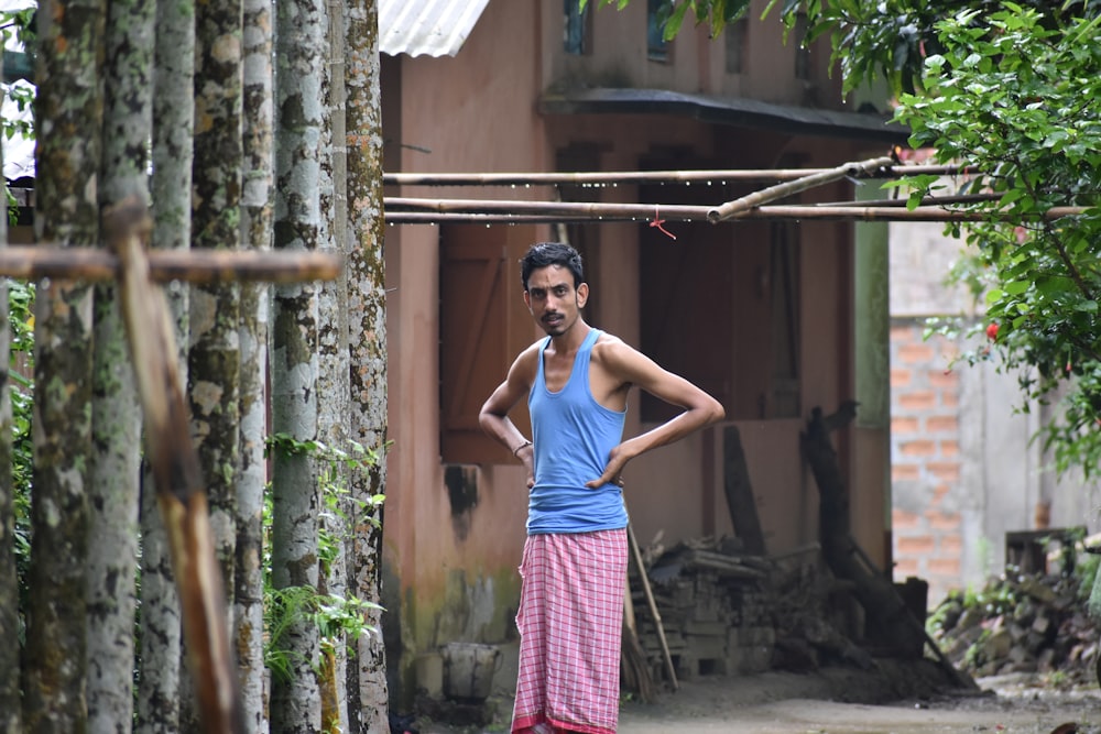 man standing near trees holding both hips