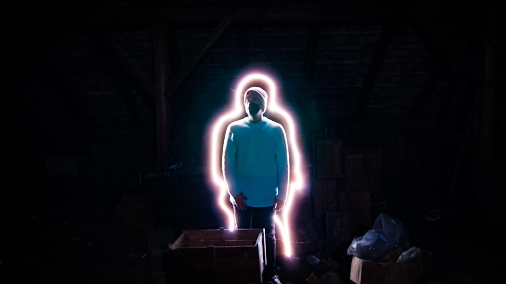 a man standing in a dark room with neon lights