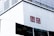 A large building facade with a prominent red and white UNIQLO logo displayed on its wall. Below the logo are several banners with brand names and imagery, suggesting a commercial area.