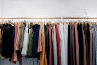 assorted-color clothes lot hanging on wooden wall rack