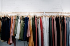 assorted-color clothes lot hanging on wooden wall rack