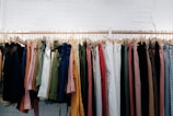 assorted-color clothes lot hanging on wooden wall rack