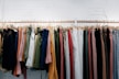 assorted-color clothes lot hanging on wooden wall rack