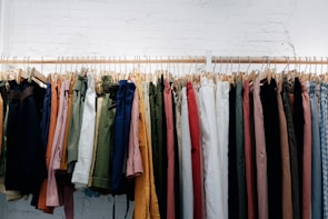 A pair of barrel pants in deep olive green displayed on a rustic wooden chair.