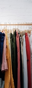 assorted-color clothes lot hanging on wooden wall rack