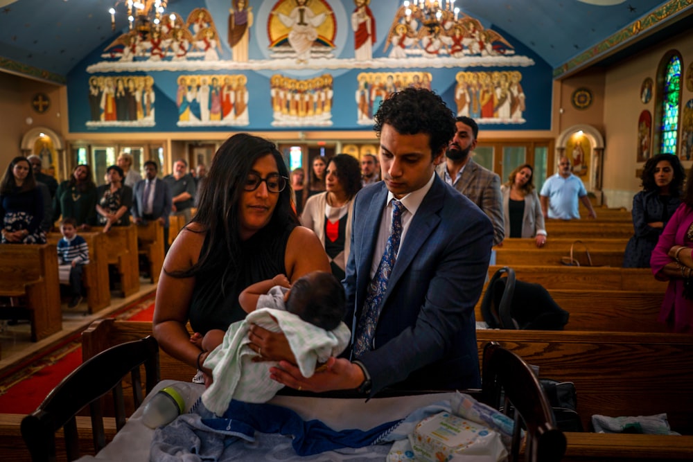 a man holding a baby in a church