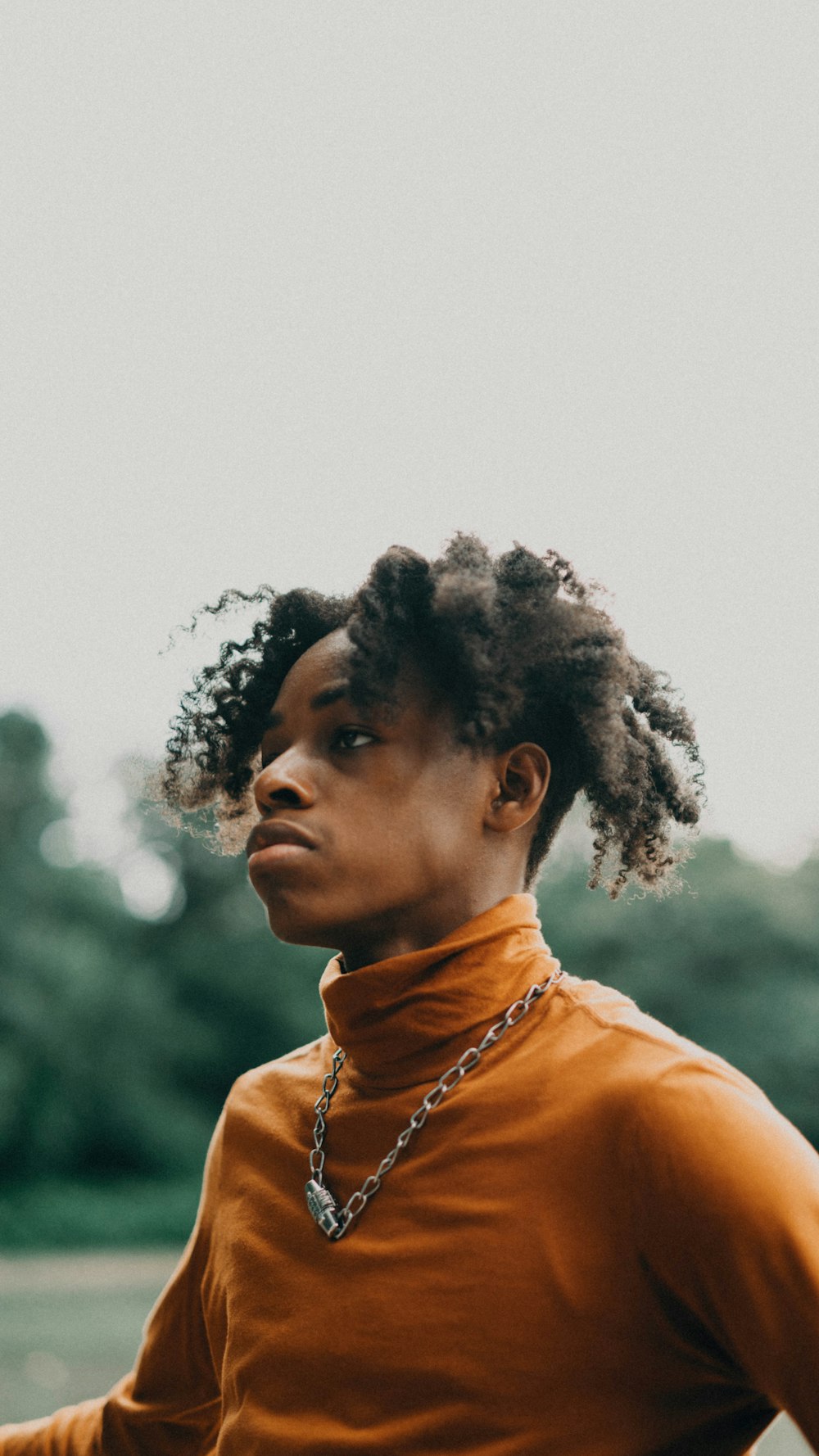 man in orange turtle-neck shirt outdoors