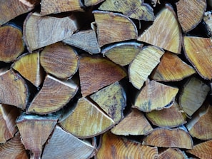 Stack of premium firewood logs neatly arranged on a rustic wooden pallet.