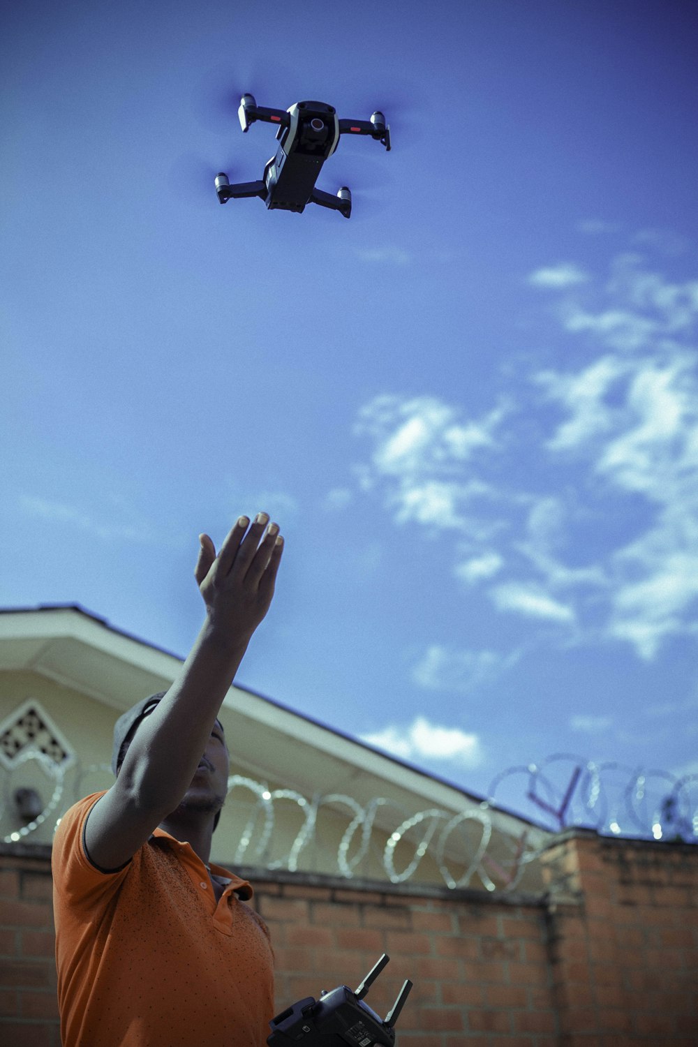 person controlling black drone outdoors