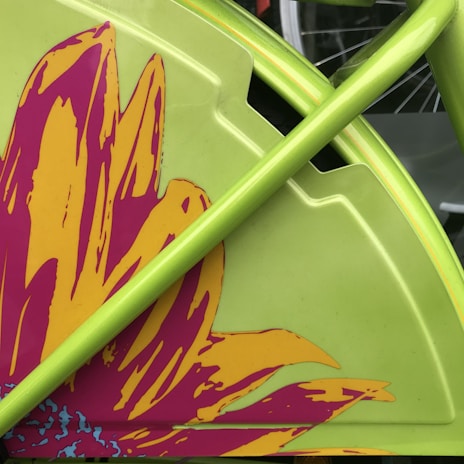 Side view of a wheelchair showing a set of spoke covers decorated with colorful geometric patterns.