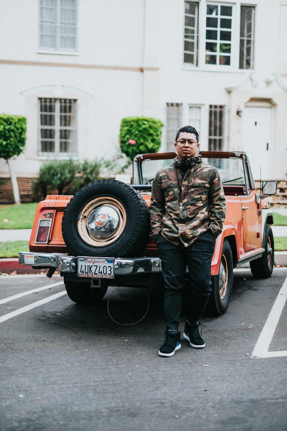 man standing beside vehicle during daytime