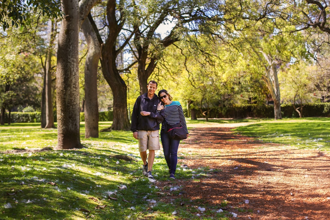 couple walking on green lawn grasses